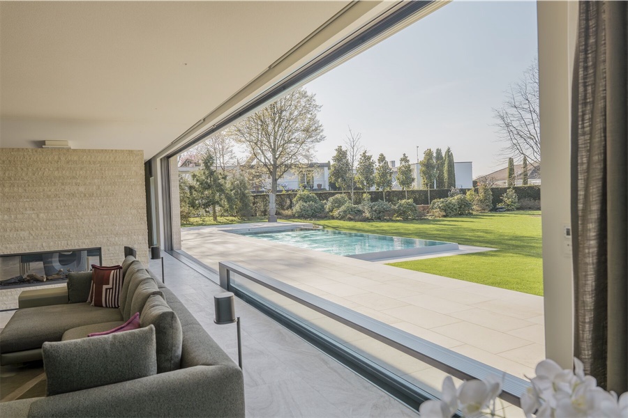 Wohnraum mit geöffneter Glasfront zum Pool